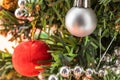 Background in the form of Christmas-tree decorations - a white and red ball, silver beads under artificial spruce branches Royalty Free Stock Photo