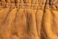 Background in the form of a fragment of the back of a winter jacket made of genuine brown soft leather