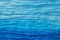 Background in the form of a synthetic material in blue with folds imitating the waves of the sea