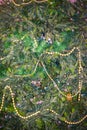 Background of frame filled with artificial Christmas tree being taken down with some garland, pearls and light strings still on it Royalty Free Stock Photo