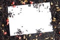 Background with a free white isolated space of black fruit tea with dried ginger and pieces of pink candied pineapple