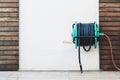 Background of a garden hose reel fixed on the wall. Royalty Free Stock Photo