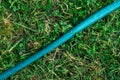 Garden hose lying on the green grass close up Royalty Free Stock Photo