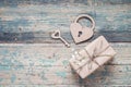 Background with gift box, small white flowers, lock-heart and key on old boards with shabby paint. Place for text. Royalty Free Stock Photo