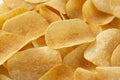 Background golden potato chips texture. Crispy unhealthy snack isolated