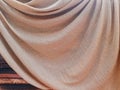 Background of golden silk cloth with folds on wood. Smooth and elegant gold colored silk. Luxury cloth satin texture. Elegant