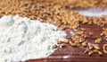 Background of Golden wheat grains and white crumbling flour scattered on wooden table