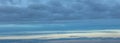 Background of gray cumulus clouds with blue and yellow stripes from the rising sun at dawn hour Royalty Free Stock Photo