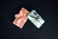 Background for greetings. Gifts wrapping in soft pink paper with dry eucalyptus branch on a black concrete background Royalty Free Stock Photo