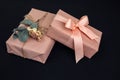 Background for greetings. Gifts wrapping in soft pink paper with dry eucalyptus branch on a black concrete background Royalty Free Stock Photo