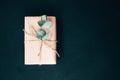 Background for greetings. Gifts wrapping in soft pink paper with dry eucalyptus branch on a black concrete background Royalty Free Stock Photo