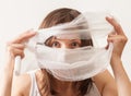 The girl covered her face with bandage on white background
