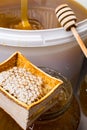 Honey in jar and big bucket, honeycomb and wooden stick Royalty Free Stock Photo