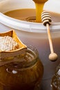 Honey in jar and big bucket, honeycomb and wooden stick Royalty Free Stock Photo