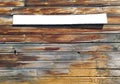 Background of horizontal wooden slats with empty white signboard for writing. Rustic white wooden sign hanging on aged wooden wall Royalty Free Stock Photo