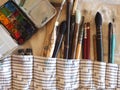 background image of an artist`s pencil case with brushes, palette, paints, watercolors, pencils