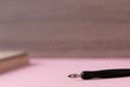 background image black ink fountain pen on pink background out of focus place for writing without people Royalty Free Stock Photo