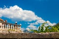 Background image. In the background is a blurred landscape of tourists, an old building, mountains and a blue sky