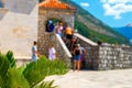 Background image. In the background is a blurred landscape of tourists, an old building, mountains and a blue sky