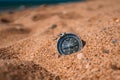 Background image of compass lying on beach with sea view, travel concept
