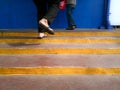 Background Image with composition of standing man while the another stepping forward feet on the brown stairway Royalty Free Stock Photo