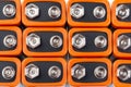 Background image of a large number of orange batteries, standing in several rows