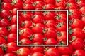 Background image of lying rows of red ripe cherry tomatoes with white rectangular frame. Top view. Flat lay, copy space Royalty Free Stock Photo