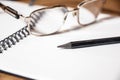 Background image of office with notepad and supplies on wooden desk, slim glasses and black pencil Royalty Free Stock Photo