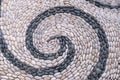 Background image of old cobblestone road backlit with low sunlight. Stone texture close up. Small pebbles on the road.