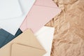 Background image of rough crumpled textured kraft paper with multi-colored cardboard envelopes. Top view. Copy space Royalty Free Stock Photo