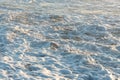 background image seawater foaming and mixing on the shore after large wave has passed in early morning sunlight
