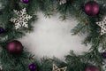 Background image of white surface with branches of Christmas tree, decorations and purple balls. Top view. Copy space Royalty Free Stock Photo