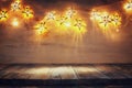 Background image of wooden board table in front of Christmas warm gold garland lights. filtered. selective focus