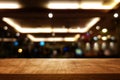 background Image of wooden table in front of abstract blurred restaurant lights Royalty Free Stock Photo