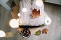Background with knitted clothes and autumn leaves, warm background, knitwear, space for text, Autumn winter concept.