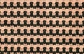 The background of a knitted fabric is orange-black with a regular geometric pattern. Openwork finely knitted woolen fabric