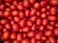 A background of a large number of small red tomatoes. Background from vegetables on a shop window.