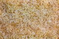 Background of long grain parboiled uncooked rice. Rice groats as background and texture