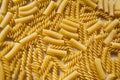 Background from macaroni fusilli and maccheroni rigati, top view. Raw pasta as background, close-up. Italian wheat pasta