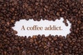 Background made of coffee beans in a heart shape with message `A coffee addict.`