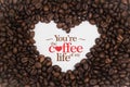 Background made of coffee beans in a heart shape with message `You`re the coffee of my life`