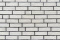 Background made of the facade of the building made white brick, a large fugue between the bricks is visible. Royalty Free Stock Photo