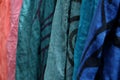The background of many colorful pashmina scarves hanging