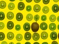 Background of many kiwi slices. One whole in the skin. Sliced kiwi on a yellow background. Raw food concept. Pattern of green Royalty Free Stock Photo