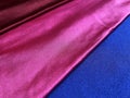 Flat surface of maroon, pink and blue shiny fabric