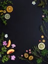 Background for the menu. Black stone background with fruits, flowers and green leaves