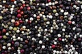 Background of a mixture of pepper varieties with peas. Heap of various pepper. Mix of red, black, and white peppercorn