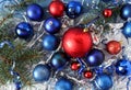 Background of multi-colored Christmas balls of red and blue, tinsel and spruce branches, top view Royalty Free Stock Photo