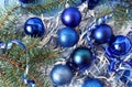 Background of multi-colored Christmas tree balls in blue, tinsel and spruce branches, top view Royalty Free Stock Photo