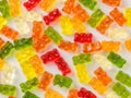 Background of multicolored gummy bears candy on white surface. Jelly sweets of differenr colors. Popular gummies made from fruit